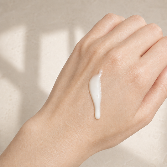 Lait nettoyant visage YLINA fleur de néroli blanc sur main, soin naturel ORÉRA éco-luxe fabriqué au Québec sans cruauté.