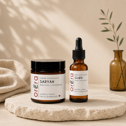 Boite ORÉRA avec crème hydratante en pot noir et sérum en flacon ambré avec pipette, étiquettes blanches minimalistes.