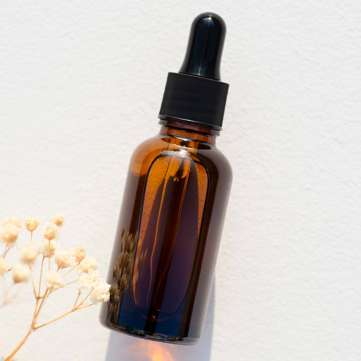 Flacon en verre ambré avec compte-gouttes noir pour sérum visage naturel.