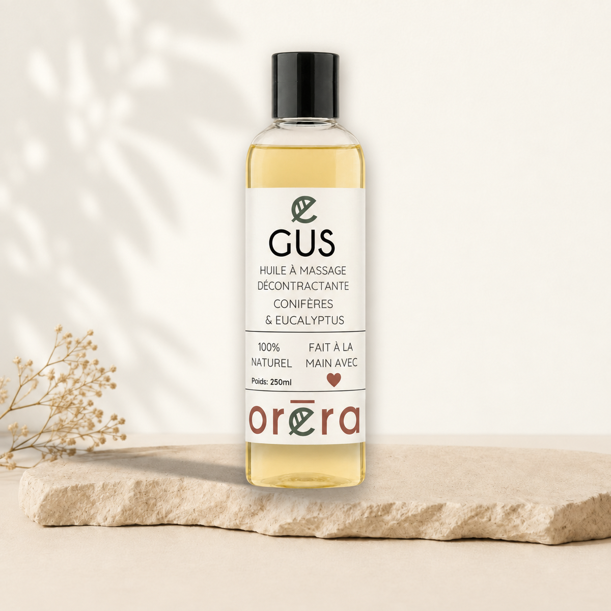 Flacon transparent d’huile à massage jaune pâle avec étiquette blanche et texte noir, bouchon noir.