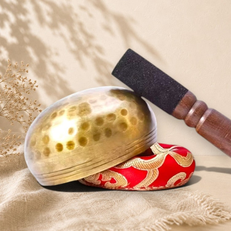 Bol tibétain en métal doré avec coussin rouge orné, artisanat québécois ORÉRA éco-luxe naturel sans cruauté.