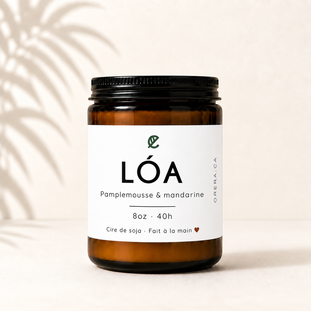 Bougie artisanale en verre ambré avec étiquette blanche minimaliste, parfum pamplemousse et mandarine.