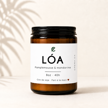Bougie artisanale en verre ambré avec étiquette blanche minimaliste, parfum pamplemousse et mandarine.