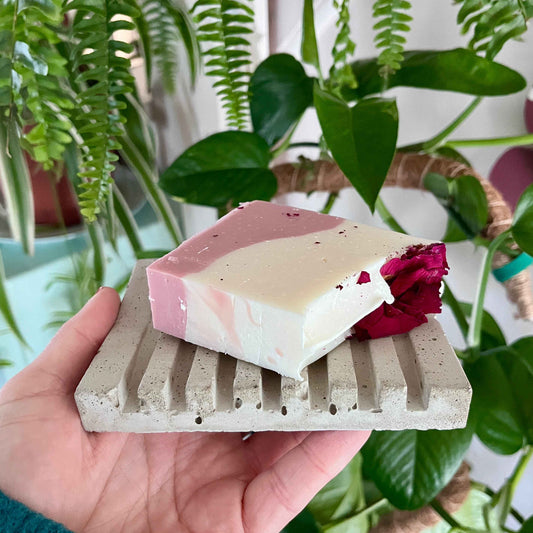 Savon artisanal rose et blanc ORÉRA posé sur porte-savon écologique en béton, fabriqué au Québec, soins naturels sans cruauté.