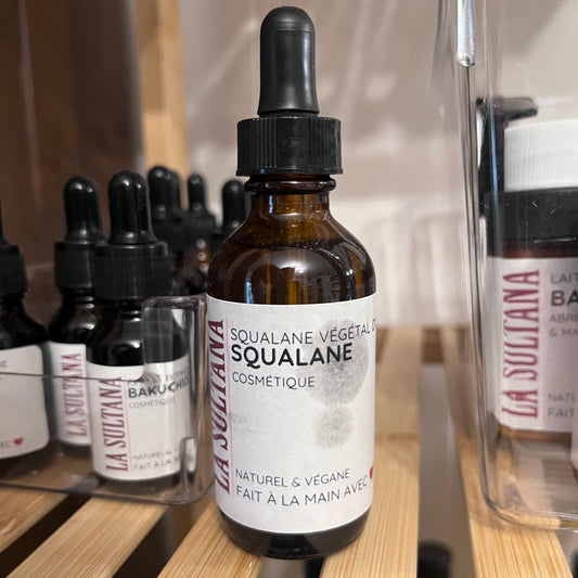 Flacon en verre ambré avec pipette noire, étiquette blanche épurée, sérum squalane végétal.