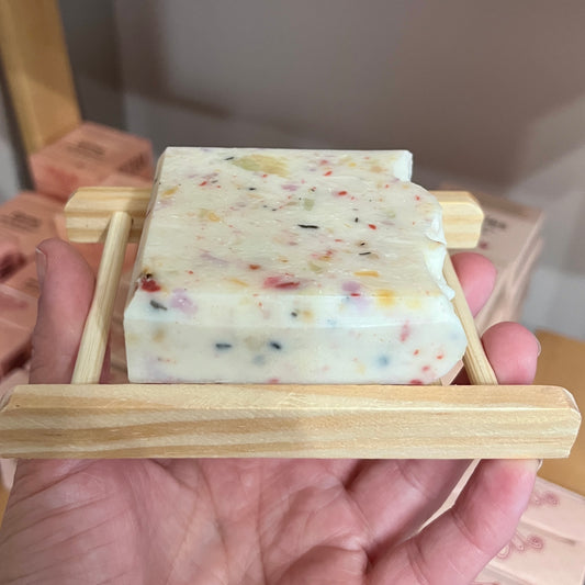 Savon blanc moucheté posé sur porte savon en bois naturel ORÉRA, fabriqué au Québec, soins naturels sans cruauté.