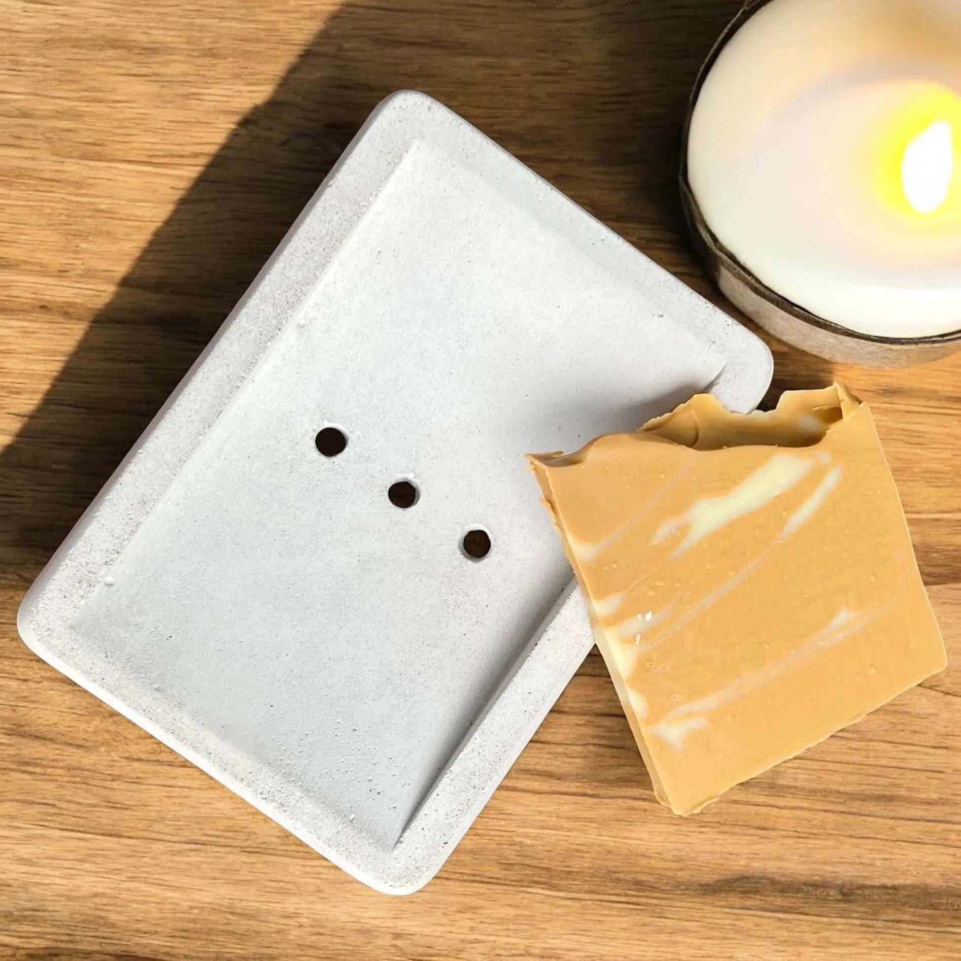 Porte-savon en béton fait main ORÉRA, éco-luxe naturel, artisanal québécois, sans cruauté, avec savon beige posé dessus.