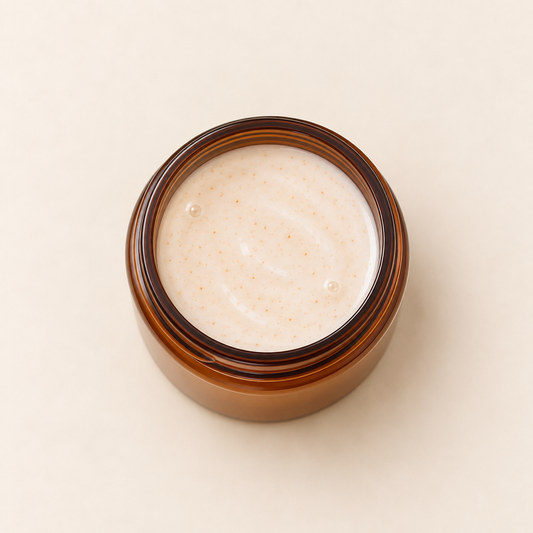 Pot en verre ambré ouvert montrant un lait nettoyant beige légèrement texturé.