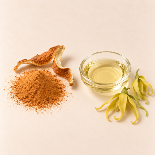 Poudre orange, huile claire en verre et fleurs jaunes Ylang-Ylang sur fond beige.