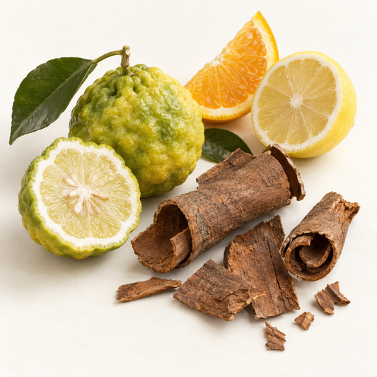 Savon artisanal oréera, couleur crème, posé sur écorces, agrumes frais verts et jaunes.