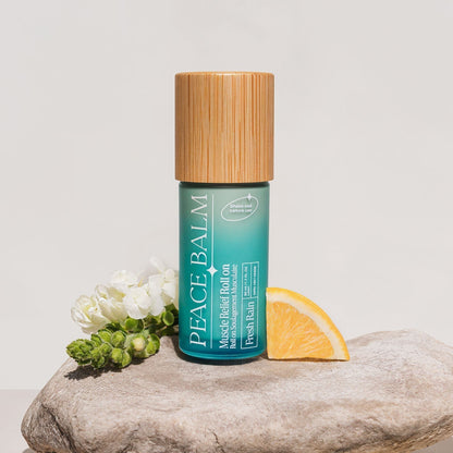 Petit flacon vert d’eau mat avec bouchon en bois clair, baume apaisant Peace Balm Fresh Rain.