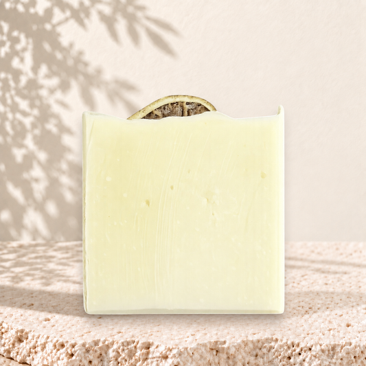 Savon carré crème avec tranche de citron séché sur le dessus, look artisanal et naturel.