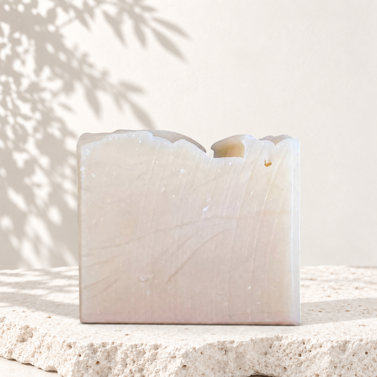 Savon artisanal beige clair à bord ondulé, texture lisse, sans ajout, éco-luxe naturel au Québec.