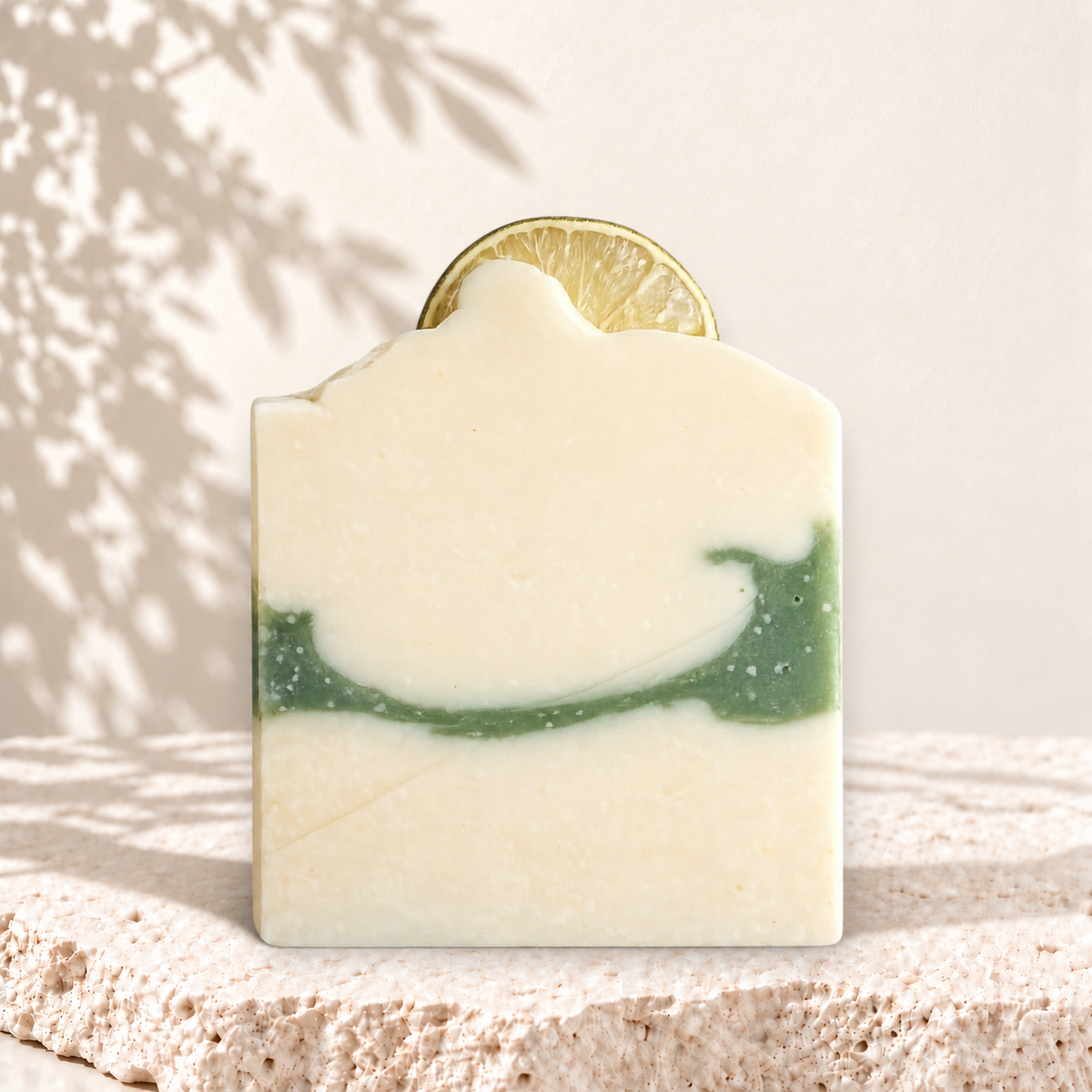 Savon rectangulaire crème avec bande verte et tranche de lime incrustée, style artisanal naturel.