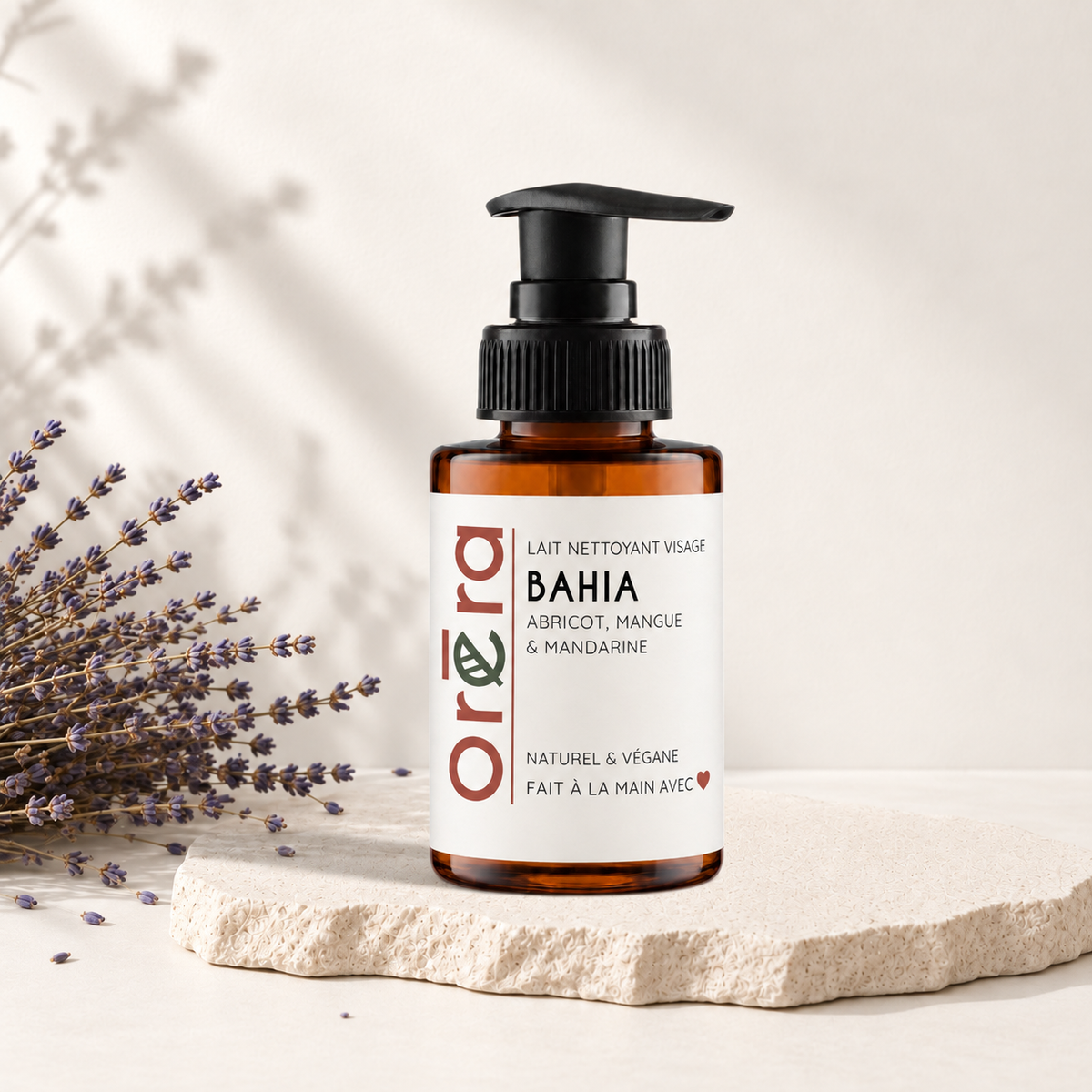 Flacon pompe ambré avec étiquette blanche et texte orange noir, lait nettoyant visage Bahia Oréra.