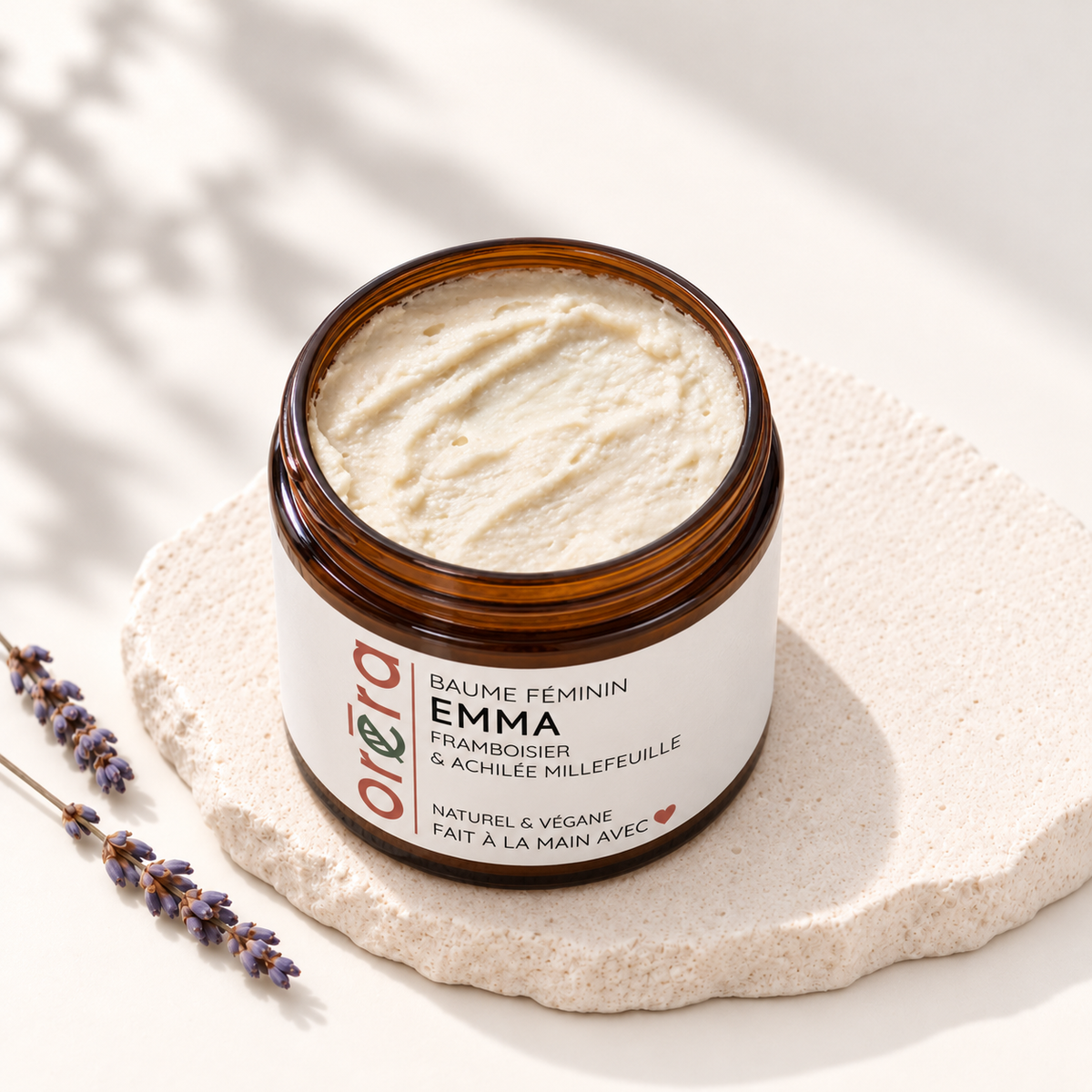 Pot ambré ouvert de baume EMMA, rempli d’un baume crème à la texture fouettée.