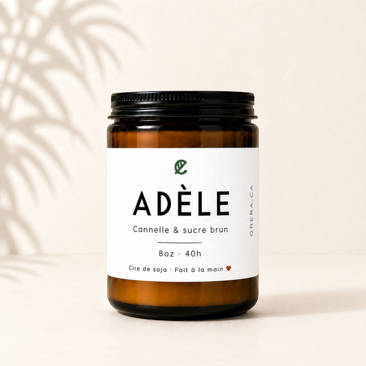 Bougie en verre ambré avec étiquette blanche minimaliste et couvercle noir, parfum cannelle et sucre brun.
