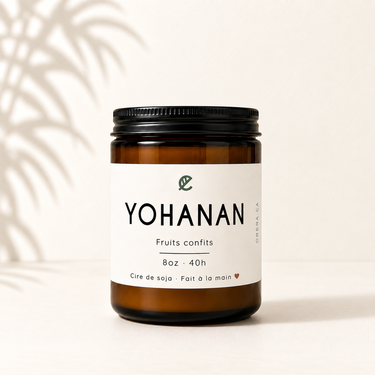 Bougie de soya ambre avec étiquette blanche minimaliste, couvercle noir, parfum fruits confits.