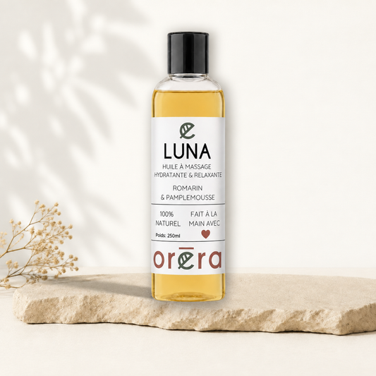 Flacon transparent d’huile de massage jaune, étiquette blanche minimaliste avec texte noir et logo Oréra rouge.