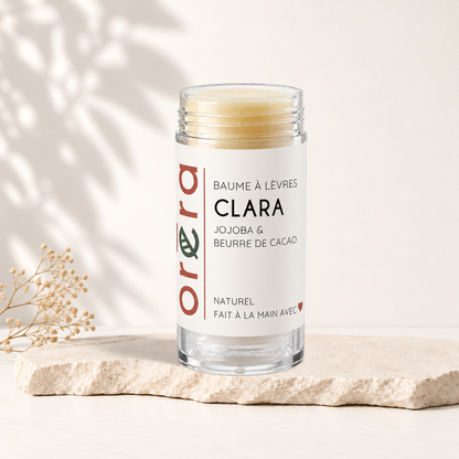 Baume à lèvres beige clair dans tube transparent avec étiquette blanche et texte rouge et vert Oréra.