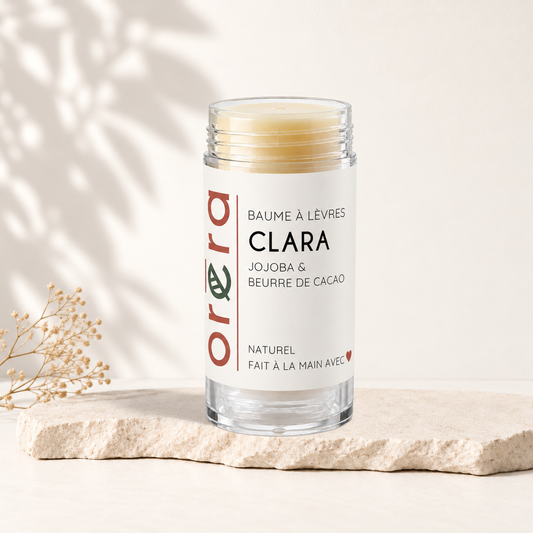 Baume à lèvres beige clair dans tube transparent avec étiquette blanche et texte rouge et vert Oréra.