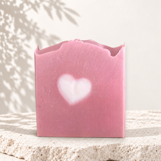 Savon carré rose à l'argile avec cœur blanc au centre, surface légèrement ondulée, fini mat.