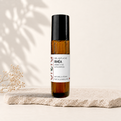 Bâton rouleau ambré avec bouchon noir et étiquette blanche minimaliste pour soin anti-acné naturel.