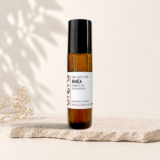 Bâton rouleau ambré avec bouchon noir et étiquette blanche minimaliste pour soin anti-acné naturel.
