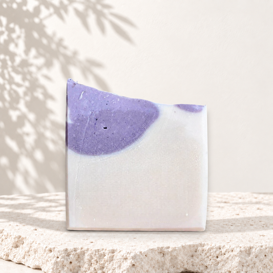 Savon carré blanc et violet avec texture lisse, style artisanal et naturel.