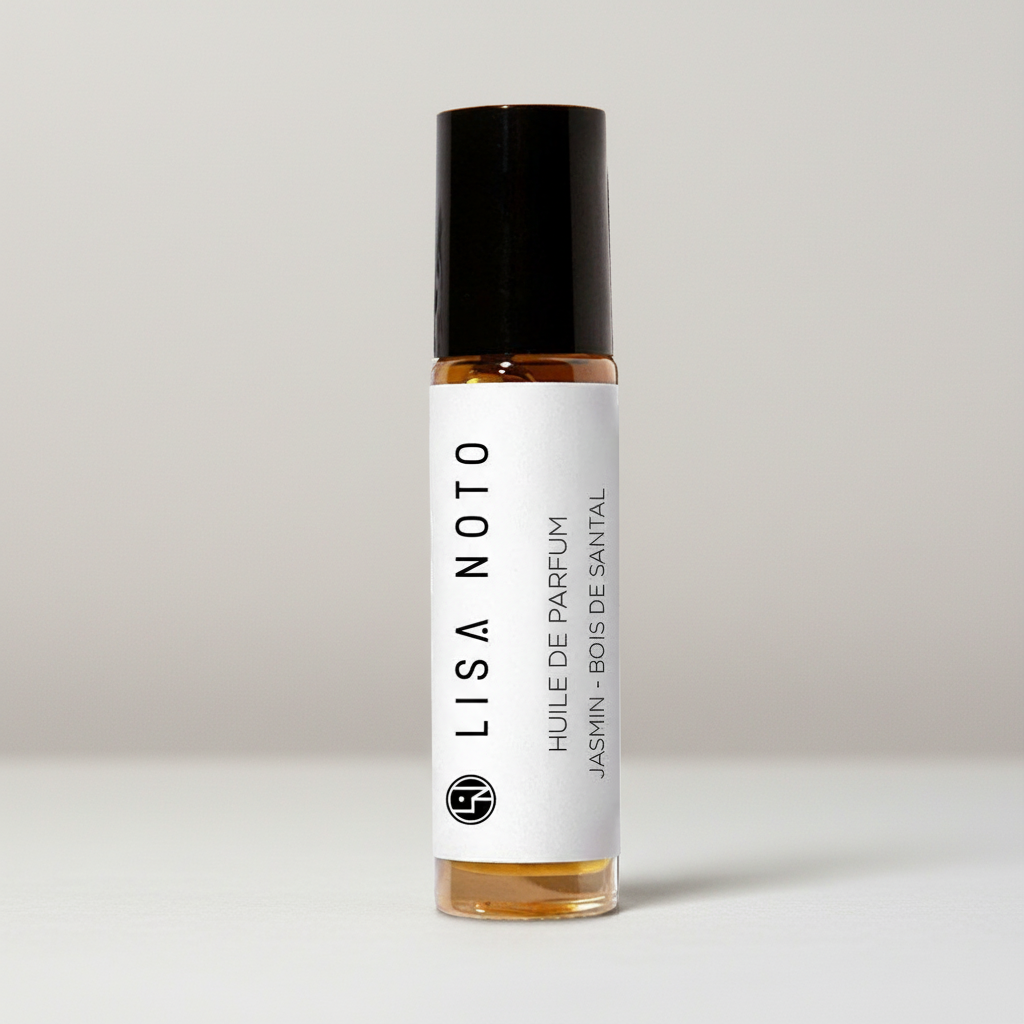 Flacon roll-on huile de parfum ambrée 10ml, étiquette blanche minimaliste, bouchon noir mat.