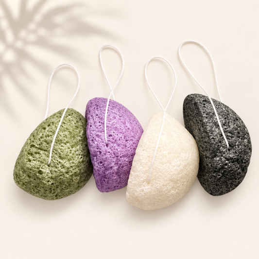 Quatuor d’éponges konjac naturelles vert, violet, blanc et noir avec cordelette suspendue.