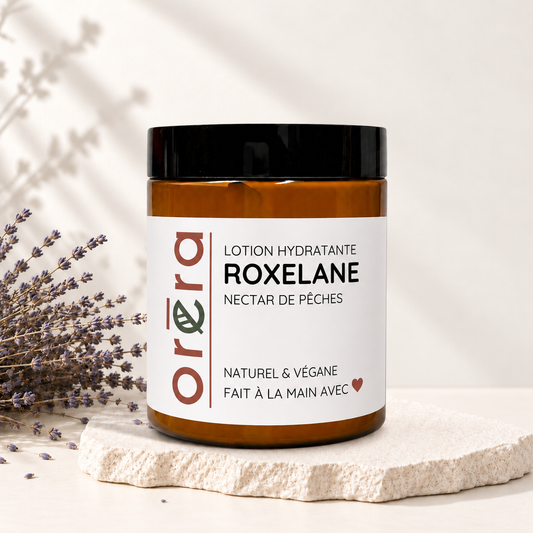 Pot ambre en verre avec couvercle noir, étiquette blanche, lotion hydratante ROXELANE nectar de pêches, style éco-luxe.