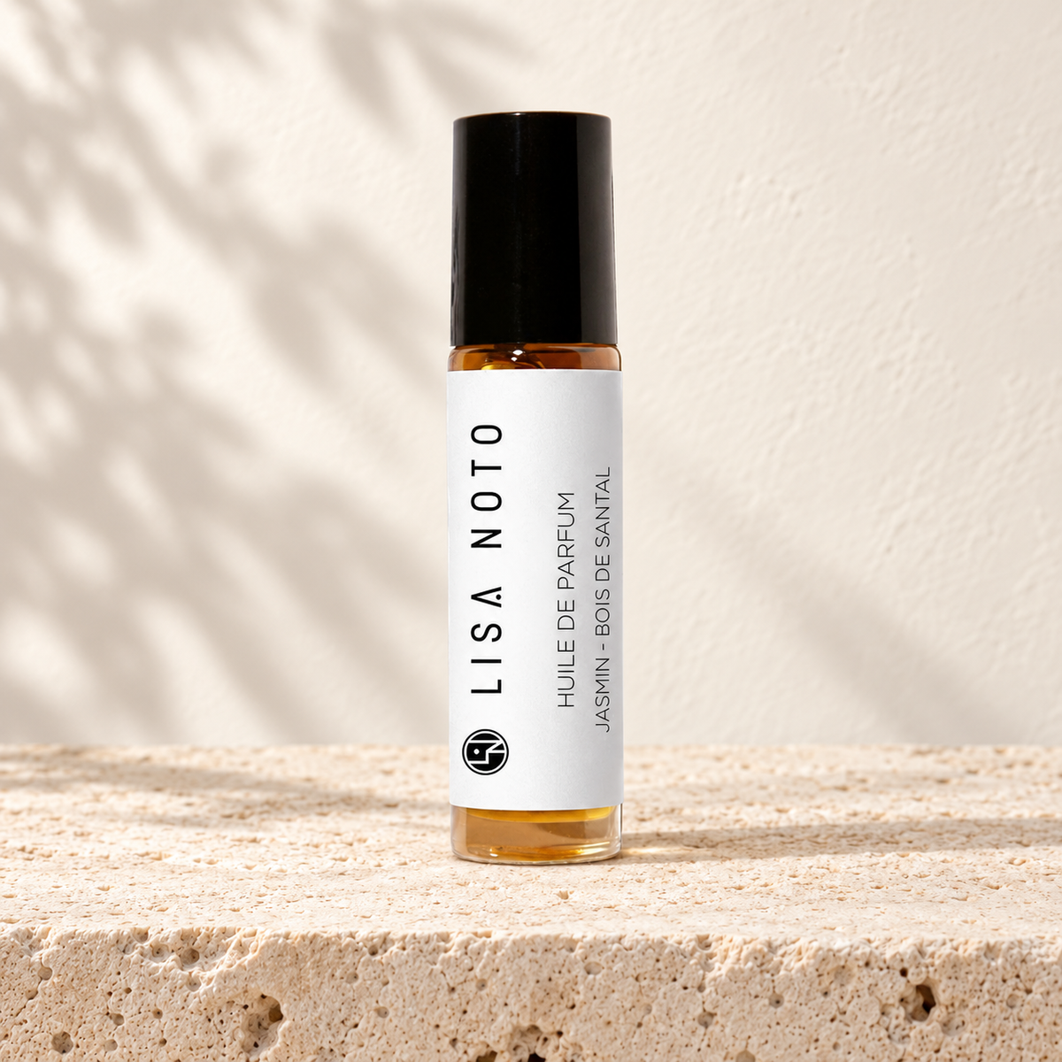 Huile de parfum Lisa Noto jasmin et bois de santal, flacon posé sur une pierre claire.
