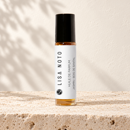Huile de parfum Lisa Noto jasmin et bois de santal, flacon posé sur une pierre claire.