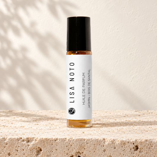 Huile de parfum Lisa Noto jasmin et bois de santal, flacon posé sur une pierre claire.