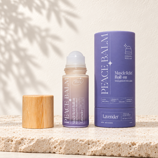 Peace Balm Lavender, flacon roll-on et étui violet d’origine, posés sur du travertin clair.