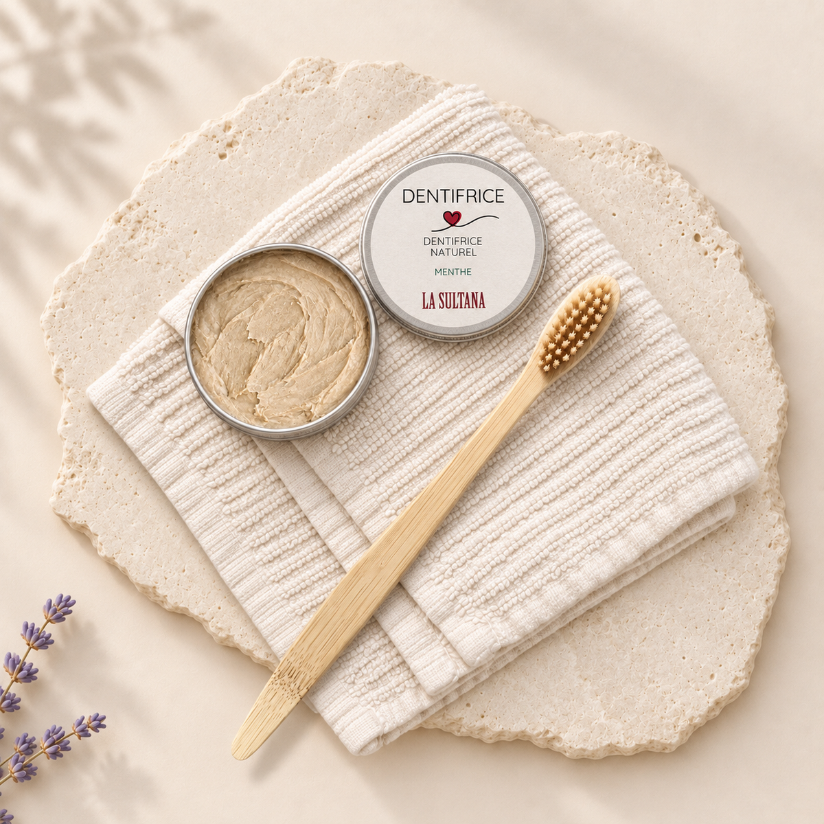 Brosse à dents en bambou naturel avec poils beige sur serviette blanche texturée.