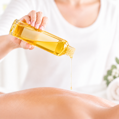 Flacon transparent d’huile jaune doré versée sur peau nue, ambiance détente spa.