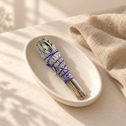 Mini bâton de sauge blanche au fil violet, non allumé, dans une coupelle en céramique ivoire.