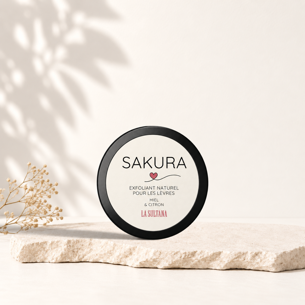 Pot rond noir avec étiquette blanche et texte noir du masque exfoliant lèvres Sakura miel citron.