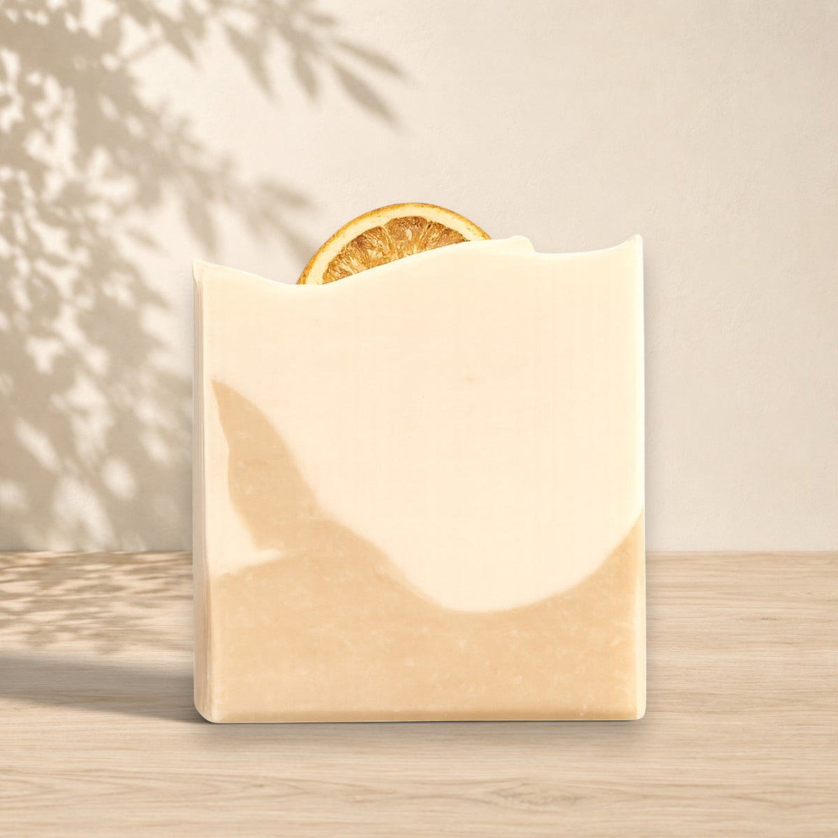 Savon au lait de coco ORÉRA beige avec tranche d'orange, éco-luxe naturel québécois sans cruauté.
