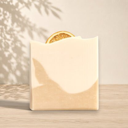 Savon au lait de coco ORÉRA beige avec tranche d'orange, éco-luxe naturel québécois sans cruauté.