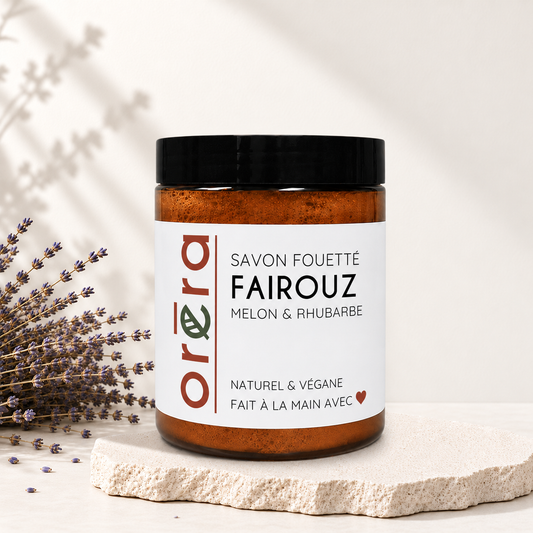 Pot en verre ambré avec couvercle noir, étiquette blanche Savon fouetté Fairouz melon & rhubarbe.
