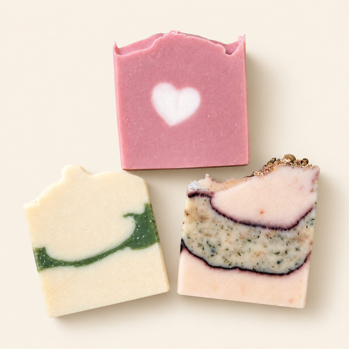 Trois savons Oréra colorés, dont un savon rose décoré d’un cœur
