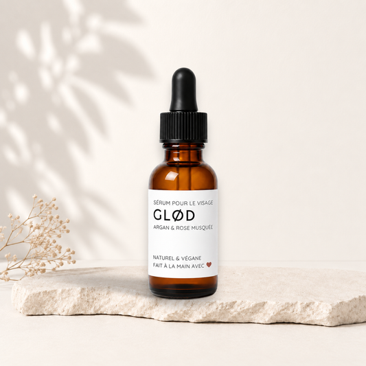Flacon en verre ambré avec pipette noire, sérum visage GLØD, étiquette blanche minimaliste.