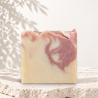 Savon carré beige avec marbrures rouge argile, texture artisanale et naturelle.